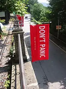 Serviettes sérigraphiées en hommage à Douglas Adams. À côté des mots "DON'T PANIC", il y a les données GPS de la ville d'Innsbruck où il a eu l'idée du Hitchhiker's Guide To The GalaxyErik van Rheenen (2017). 16 Fun Facts About The Hitchhiker’s Guide to the Galaxy.(Anglais). Consulté 17-12-2022..