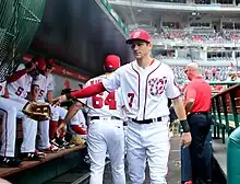 Un joueur de baseball jette son gant sur le banc de touche d'un stade de ligue majeur américain.