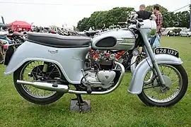 Triumph Twenty One avec pare-boue arrière « bathtub », nacelle d'optique intégrée, pots « saucisson », grips pour les genoux et porte-paquet sur le réservoir (1961).