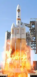 Décollage du lanceur entouré des flammes dues à l'hydrogène expulsé par les moteurs avant leur mise à feu.