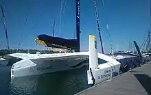 Coque centrale et flotteur tribord. L'arrière du bateau est blanc, au contraire de l'avant, qui est bleu sombre.