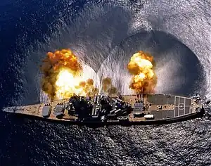 Le cuirassé américain USS Iowa tirant une bordée de ses 3 pièces triples de 406&nbsp;mm.