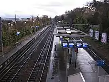 Photographie couleur. Vue supérieure de trois voies et deux quais.