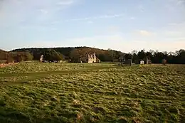 Photographie couleur de ruines dans un paysage rural peu vallonné.