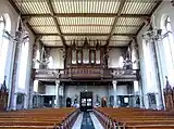 Vue intérieure de la nef vers la tribune de l'orgue Louis Mockers (1831-1896).