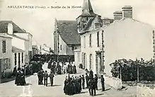 Photographie en noir et blanc de nombreuses personnes sortant d'une église.