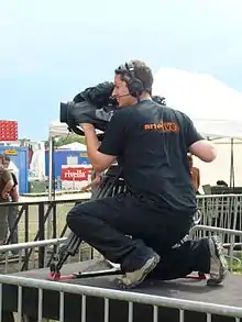 Photographie d'un homme regardant dans une caméra.