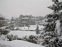 Photographie de quelques maisons sur une colline.