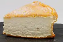 Photo d’une tranche de fromage sur une planque d’ardoise.