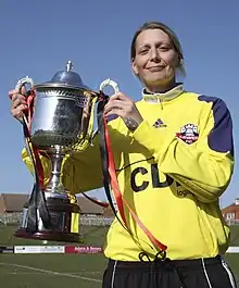 photographie: une jeune femme porte une coupe dans un stade