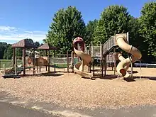 Photographie d'une installation de bois et plastique avec des toboggans.