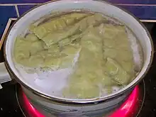 Photographie de pâtes carrées dans de l'eau bouillante.