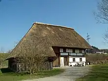 Maison avec un imposant toit de chaume de roseau