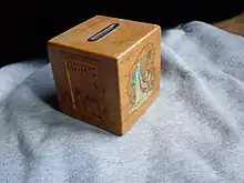 Tire-lire en bois qu'on peut ouvrir avec une petite clé. Publicité d'Allianz Allemagne du début des années 1960.