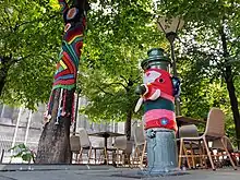 Arbre et fontaine recouverts de tissus tricotés.