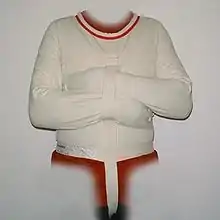 Photographie d’un vêtement blanc avec des manches attachées sur le devant.